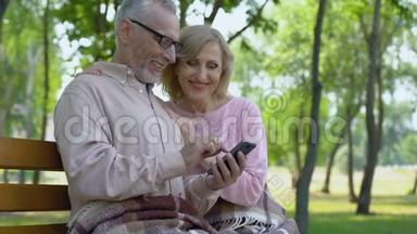 祖父和祖母欣赏智能手机应用程序中的<strong>儿童照片</strong>